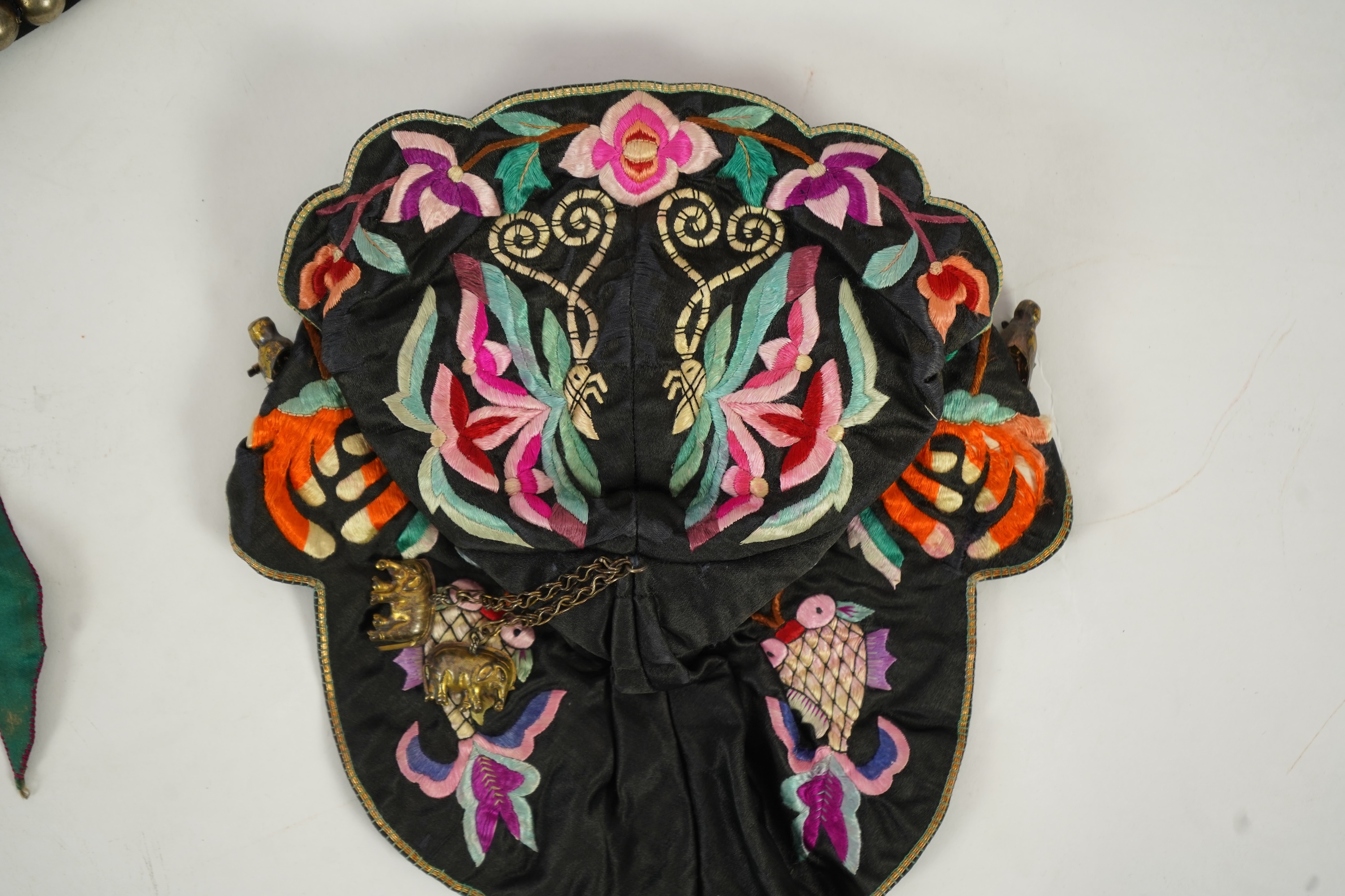 Two Chinese embroidered silk wedding skirts, late Qing, five hats, trousers, two skirt panels and two others, collar and a panel